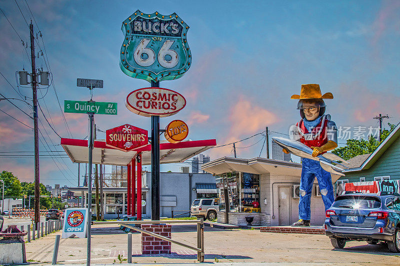俄克拉何马州塔尔萨66号公路上的urio和纪念品商店，上面有太空牛仔拿着火箭的雕像，这是由复古加油站制作的。
