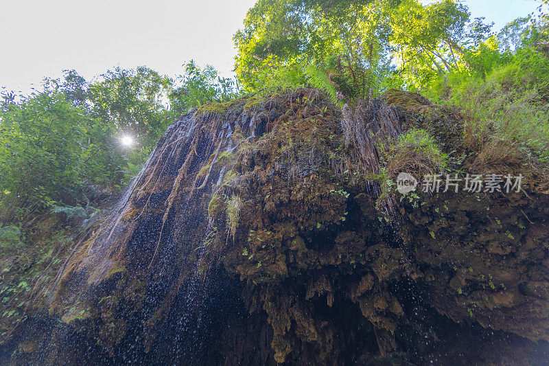 瀑布以天然的钟乳石和石笋岩壁悬于洞顶。环境的探索。景观背景。侵蚀