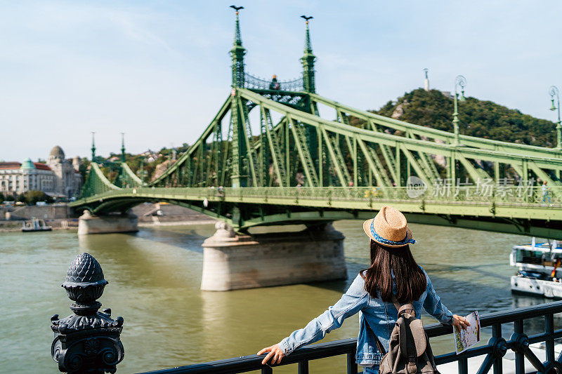 在布达佩斯自由桥附近观看多瑙河的妇女