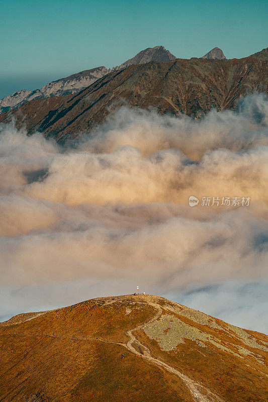 塔特拉山脉和阳光的秋景。云朵飘浮于山峰之上