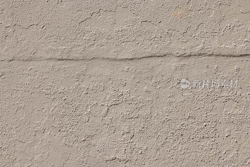 旧的新粉刷的米色混凝土墙的一部分