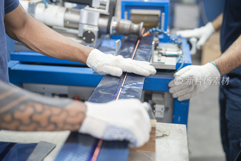 太阳能电池板工厂工人操作组装机器的特写镜头