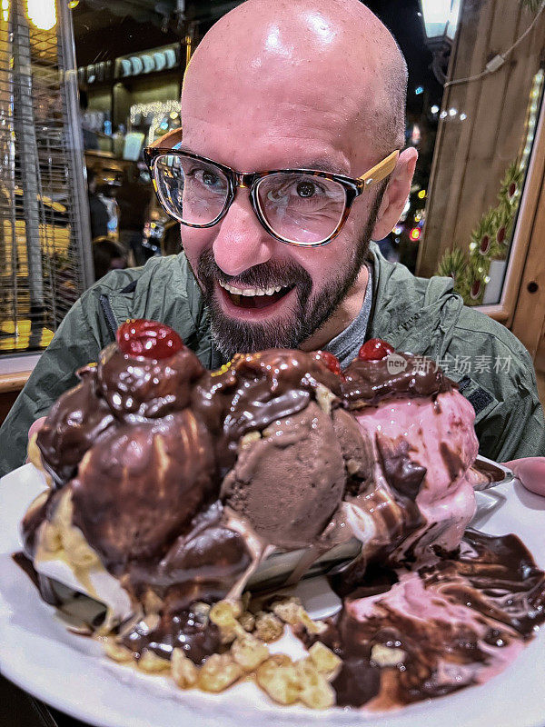 秃头男子展示一个巨大的冰淇淋。