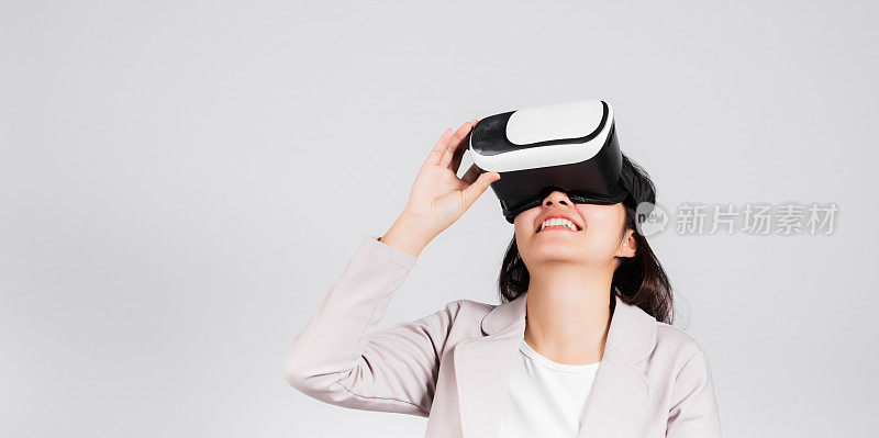 微笑的女人自信兴奋地戴上VR头戴设备进行虚拟现实体验