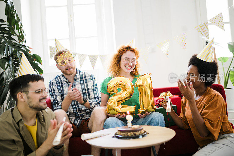 一群年轻人在享受生日聚会，朋友们在生日聚会上玩得很开心