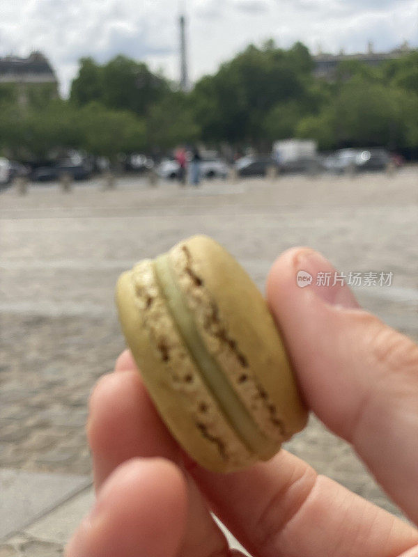 马卡龙在一个人手里买来吃，在巴黎大街上