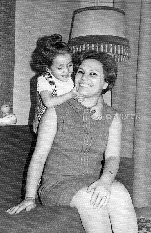 60年代的复古图片:微笑的中年妇女与她的女儿合影，60年代