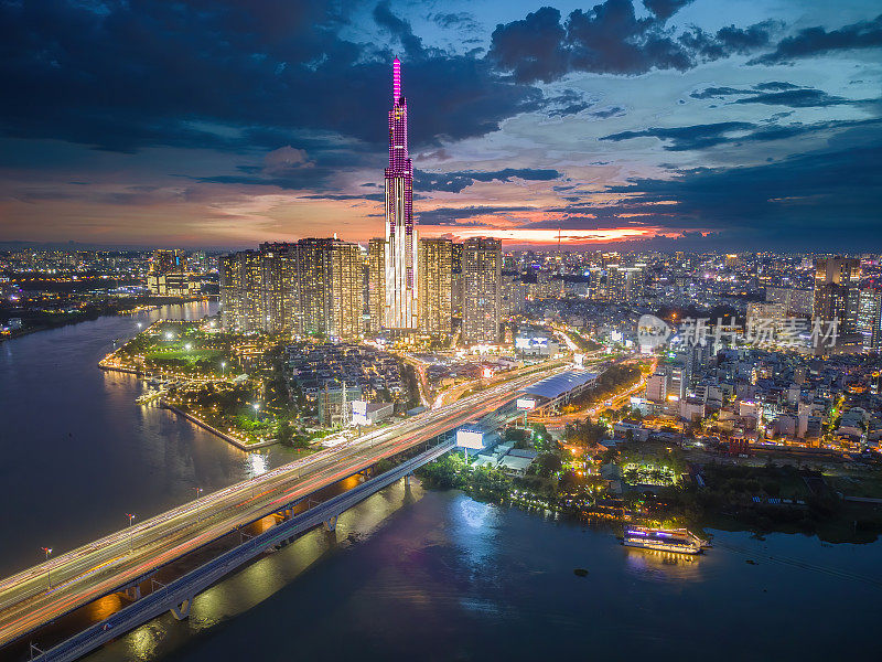 从空中俯瞰81号地标的日落景观——一幢超高的摩天大楼和西贡大桥，西贡河沿岸的发展在光线下十分流畅