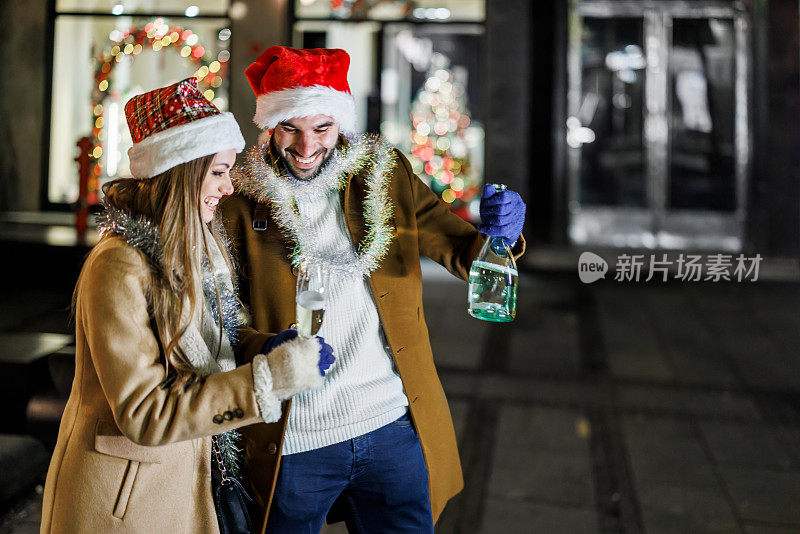 一个年轻人和他美丽的女友们走在街上，喝着酒。