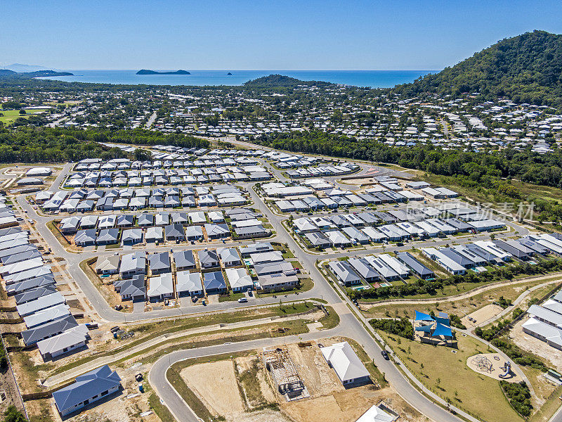 已建成的凯恩斯郊区鸟瞰图，有新的住房发展，珊瑚海和双岛礁在远处