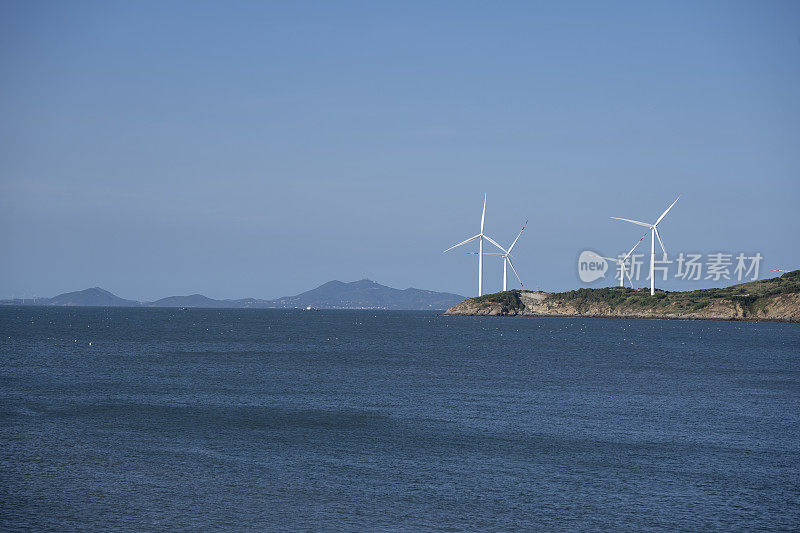 风平浪静的大海后面是风力发电站