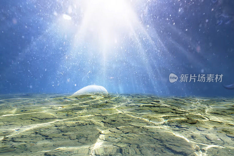 离焦模糊透明的蓝色水下表面纹理与飞溅和气泡。潮流抽象的自然背景。阳光下的海浪，复制空间。蓝色的海底水彩闪闪发光