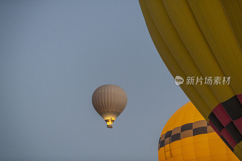 在日出时飞行的彩色热气球的特写视图