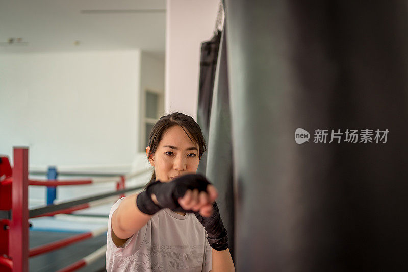 美丽的女人亚洲拳击手快乐和乐趣健身拳击和拳击袋