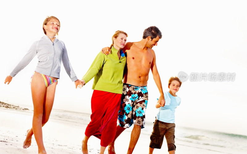 幸福的一家人在度假，在海边漫步