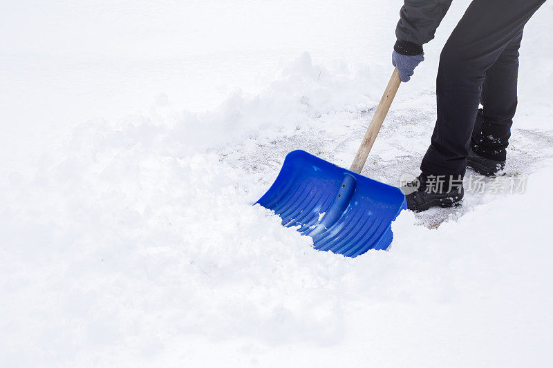 人们在冬天用铁锹清扫积雪。