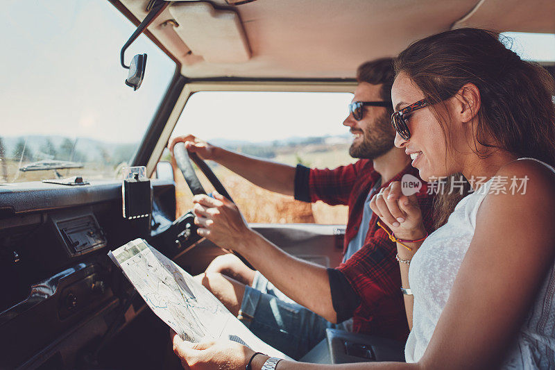 一对年轻夫妇在公路旅行中使用地图问路