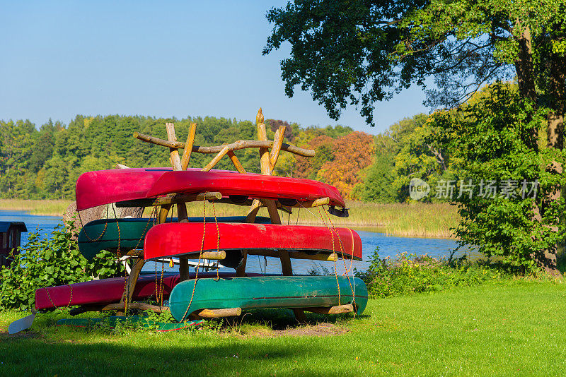 夏天，湖上的架子上放着不同的独木舟