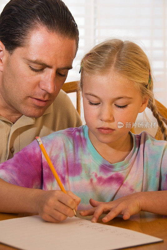 父亲帮助女儿做家庭作业