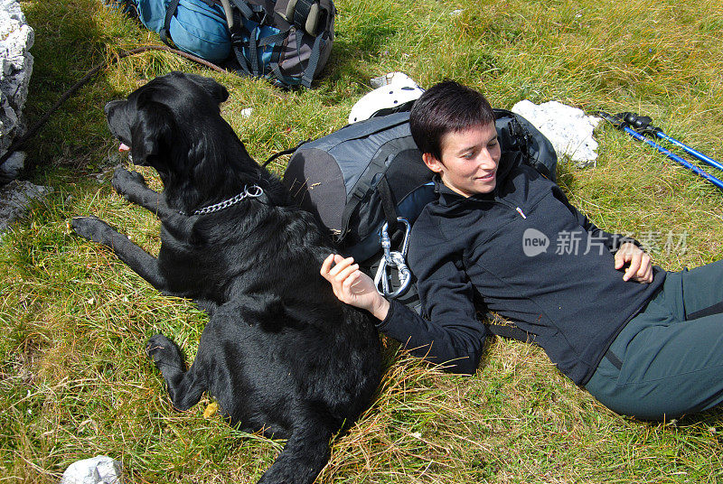 和一只黑色拉布拉多犬在山上休息