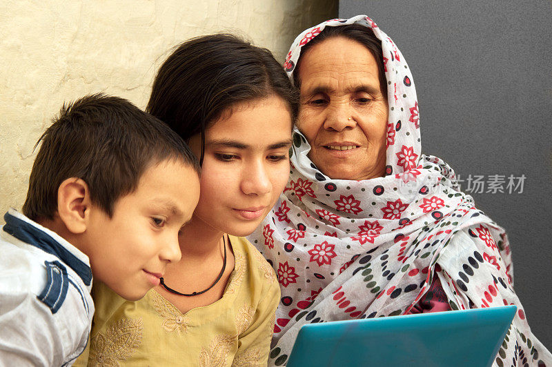 印度农村妇女和小女儿一起使用笔记本电脑