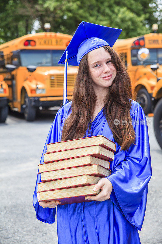 毕业少女穿着毕业礼服拿着书