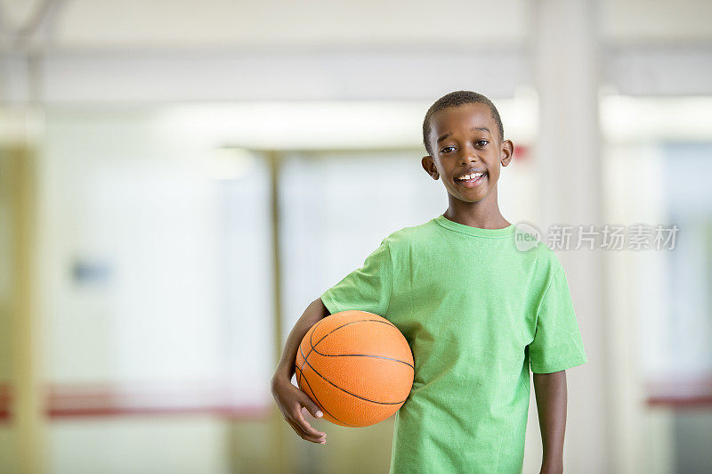 一个男孩在比赛后拿着篮球
