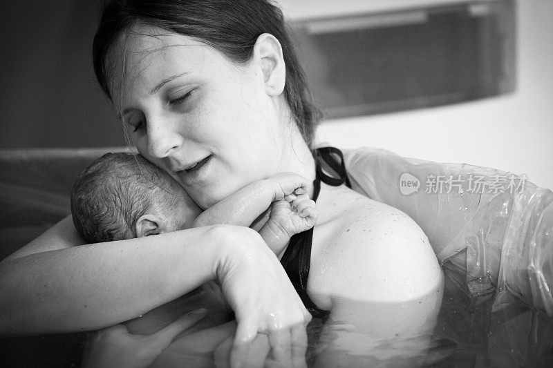 母亲在家中水中分娩后拥抱新生儿