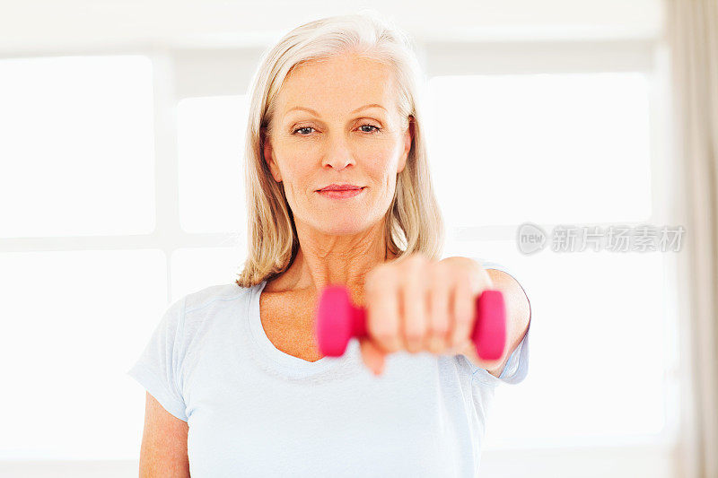 积极的老年妇女用哑铃锻炼
