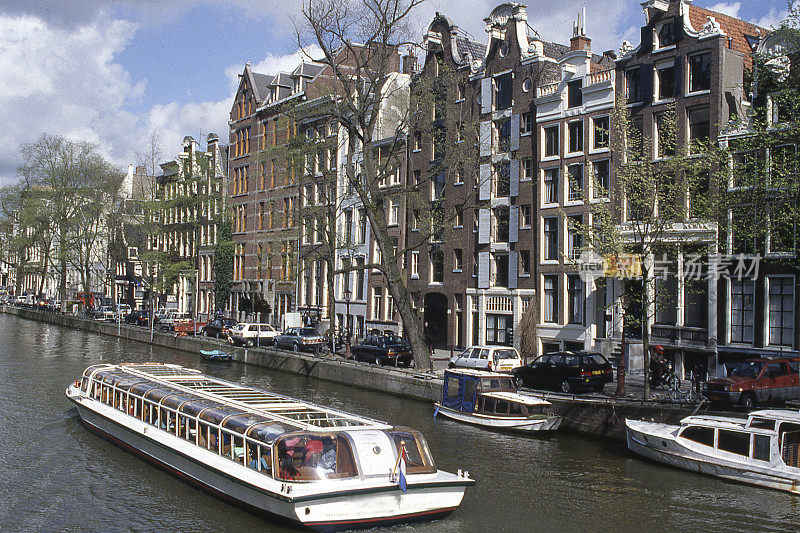 运河游船沿街道和建筑物荷兰阿姆斯特丹