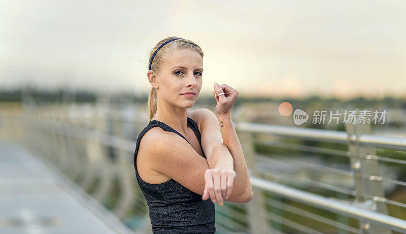 年轻的成年女运动员运动前伸展手臂