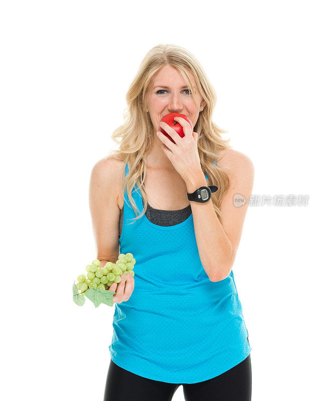 微笑的女运动员在吃苹果