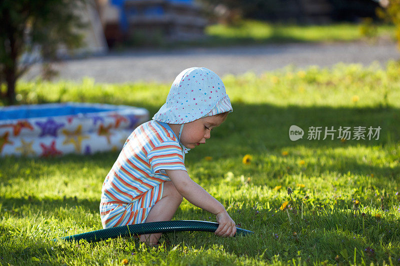 孩子们在草坪上玩水管