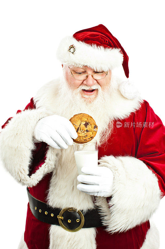圣诞老人在孤立的背景下蘸牛奶饼干