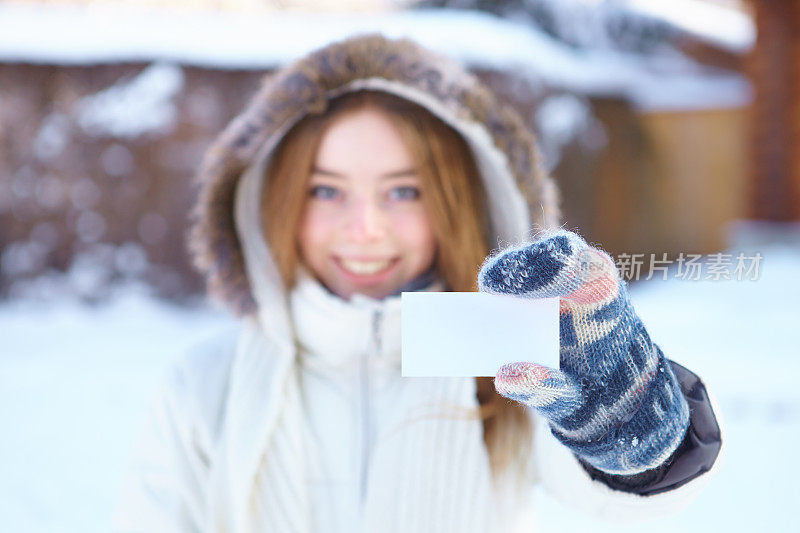 年轻漂亮的女人，拿着空白名片。冬天。
