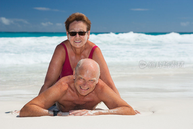 老年人挑战世界，一对夫妇在白色沙滩上