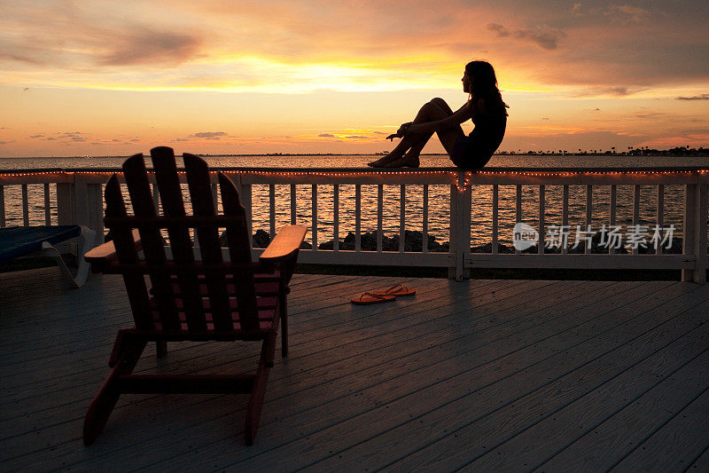 小女孩在海湾上欣赏日落
