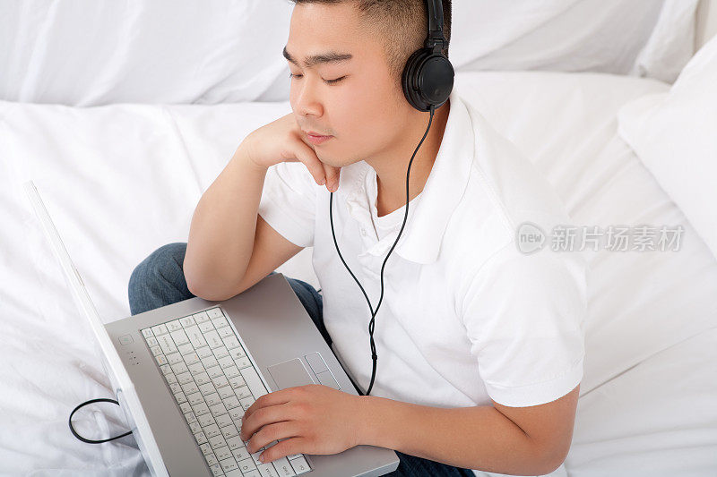 亚洲男人在卧室里听耳机