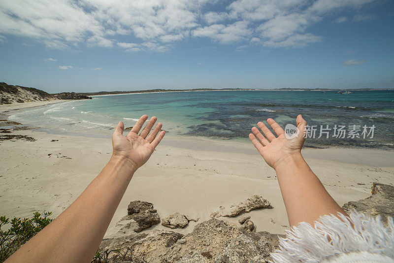 女人的手臂伸向袋鼠岛的一个美丽的海湾