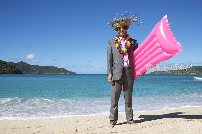 旅游商人站在明亮的粉红色气垫热带海滩