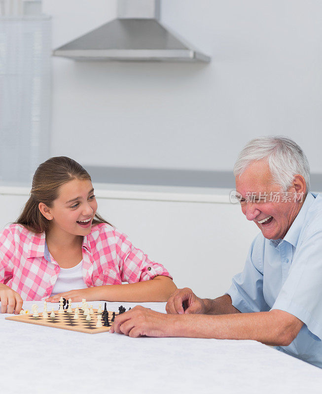笑着玩象棋的爷爷和孙女