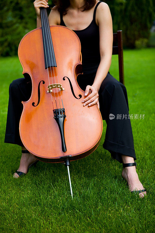 美丽的女子大提琴手在户外演奏大提琴