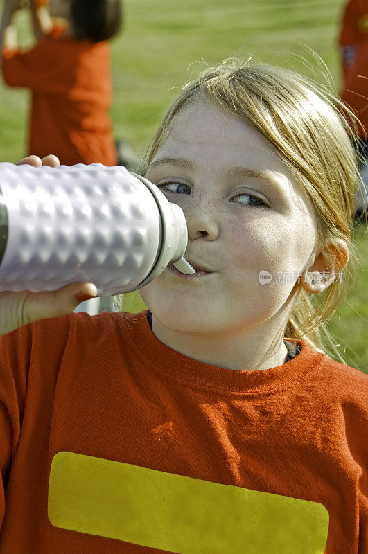年轻女孩喝水瓶里的水