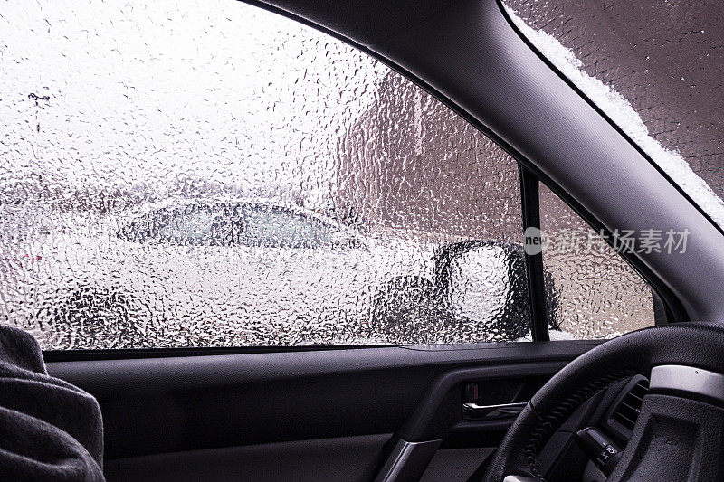 在冰天雪地的暴风雨中透过被冻住的车窗看