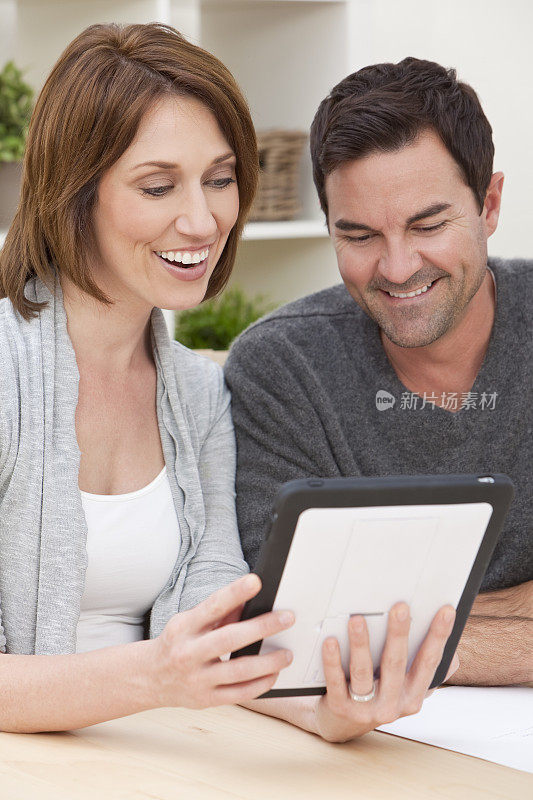 幸福的男女夫妇在家里使用平板电脑