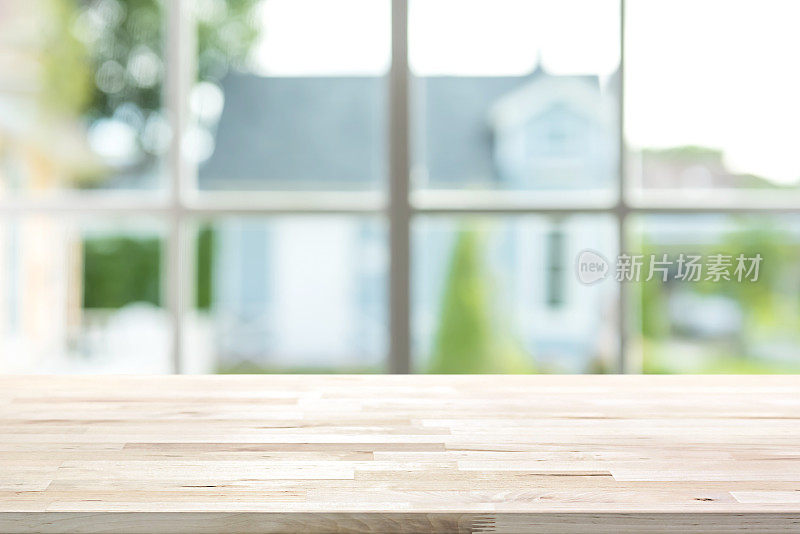 屋内的木质桌面，背景是窗外模糊的绿色花园