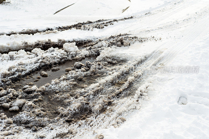 雪地背景的道路，冬季纹理与轮胎痕迹和泥