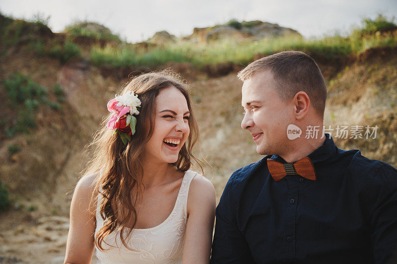户外沙滩婚礼，时尚的幸福微笑的新郎和新娘有乐趣和笑着看着对方的特写