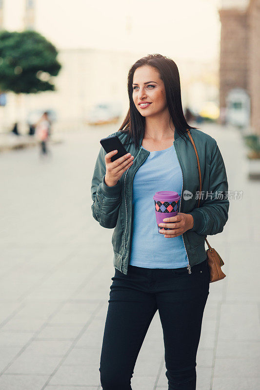 女人在户外发短信喝咖啡