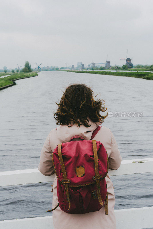 荷兰一名妇女在风车附近散步